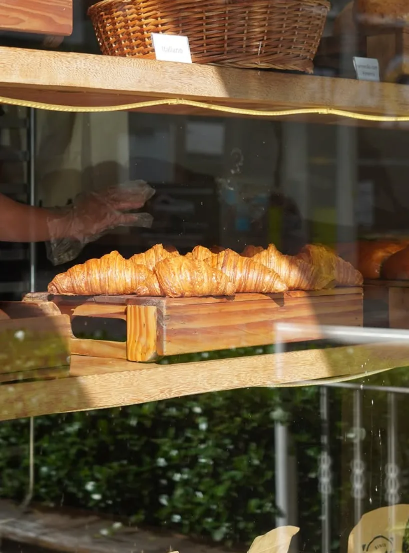 Croissants na vitrine iluminada pelo sol da manhã